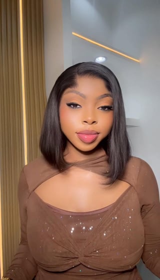 Woman with long black hair and pink lipstick wearing a sparkly brown top